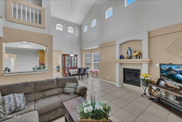 444 Ghost Flower St, Horizon City, TX 79928 - tiled living area with a high ceiling, a fireplace, and healthy amount of natural light