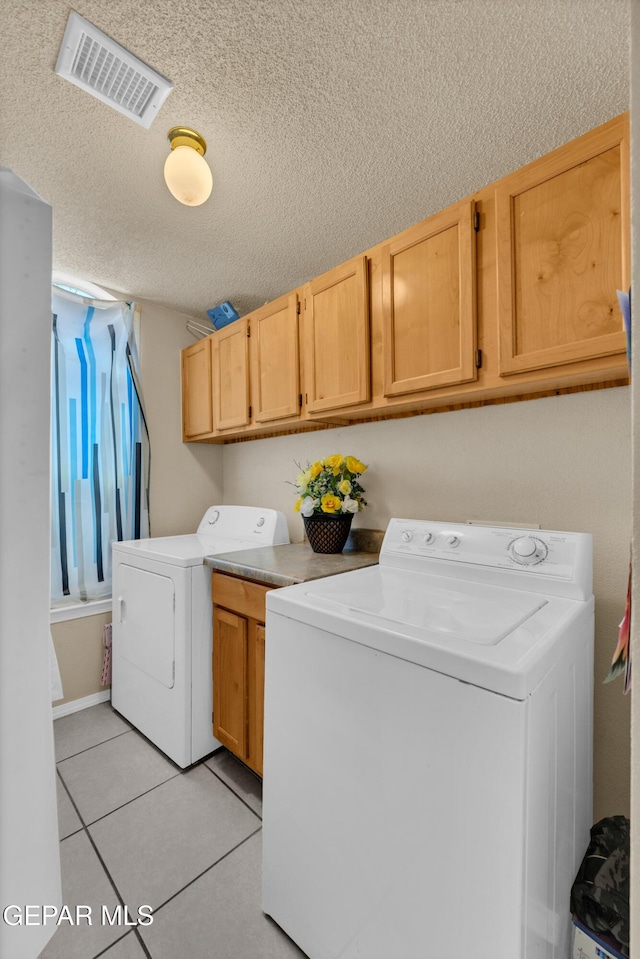 444 Ghost Flower St, Horizon City, TX 79928 - laundry room featuring cabinet space, washer and clothes dryer, light tile patterned floors, and a textured ceiling