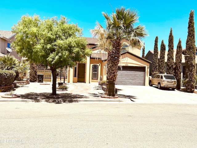 444 Ghost Flower St, Horizon City, TX 79928 - view of property hidden behind natural elements with an attached garage, concrete driveway, and stucco siding