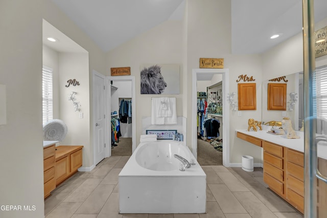 12416 Paseo Largo Cir, El Paso, TX 79928 - bathroom featuring lofted ceiling, a tub with jets, a spacious closet, healthy amount of natural light, and vanity