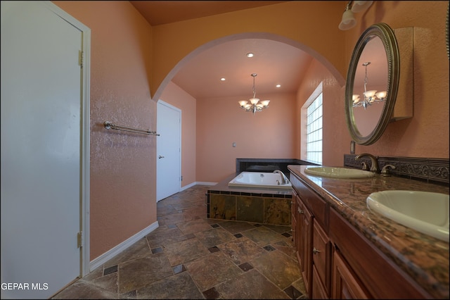 5140 Camino De La Vista Dr, El Paso, TX 79932 - bathroom featuring a chandelier, a garden tub, stone tile flooring, double vanity, and recessed lighting