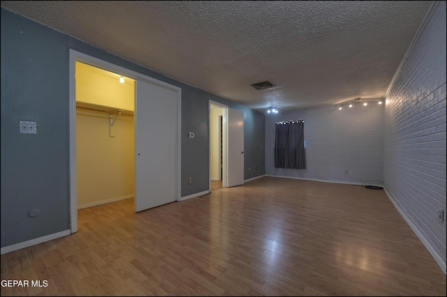 5140 Camino De La Vista Dr, El Paso, TX 79932 - unfurnished bedroom with wood finished floors, a textured ceiling, baseboards, and a spacious closet