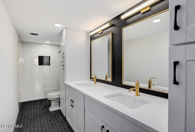 1800 N Stanton St Unit 603, El Paso, TX 79902 - bathroom with double vanity, toilet, tiled shower, and recessed lighting