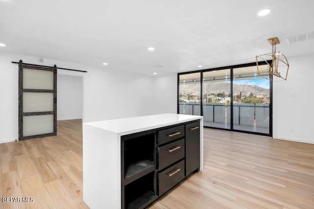 1800 N Stanton St Unit 603, El Paso, TX 79902 - kitchen featuring a barn door, floor to ceiling windows, light wood-style floors, recessed lighting, and light countertops