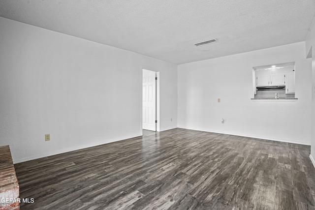 4745 Sierra Madre Dr, El Paso, TX 79904 - unfurnished living room featuring dark wood-style floors, a textured ceiling, and baseboards