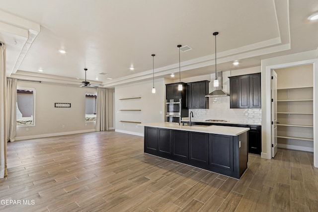 2352 Kolt Ct, El Paso, TX 79911 - kitchen featuring a raised ceiling, a ceiling fan, a sink, light countertops, and light wood-type flooring