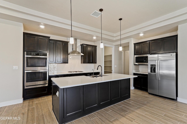 2352 Kolt Ct, El Paso, TX 79911 - kitchen featuring stainless steel appliances, wall chimney range hood, light wood-style flooring, light countertops, and baseboards