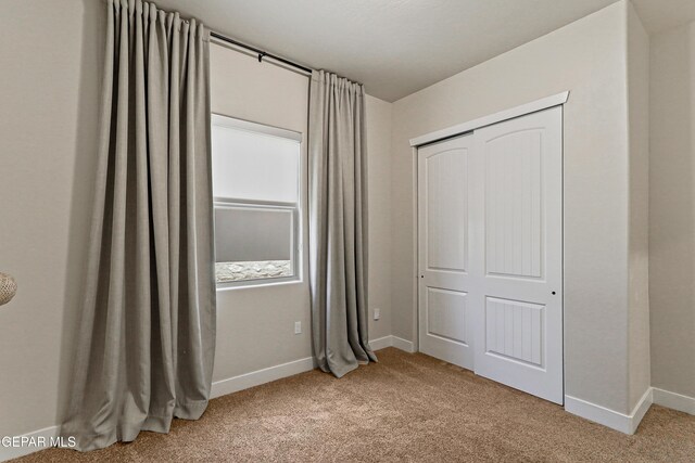2352 Kolt Ct, El Paso, TX 79911 - unfurnished bedroom featuring light colored carpet, baseboards, and a closet