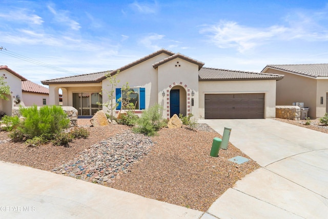 2352 Kolt Ct, El Paso, TX 79911 - mediterranean / spanish-style house with an attached garage, concrete driveway, stucco siding, and a tiled roof