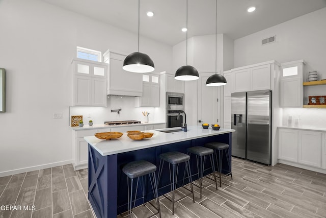 1449 Indigo Sky St, El Paso, TX 79928 - kitchen featuring appliances with stainless steel finishes, a sink, tasteful backsplash, light countertops, and wood tiled floors