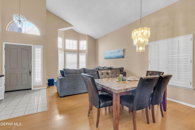 6800 Canyon Run Dr, El Paso, TX 79912 - dining area featuring a chandelier, high vaulted ceiling, light wood-style flooring, and baseboards