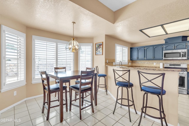 6800 Canyon Run Dr, El Paso, TX 79912 - dining space with a textured ceiling, a chandelier, baseboards, and light tile patterned flooring