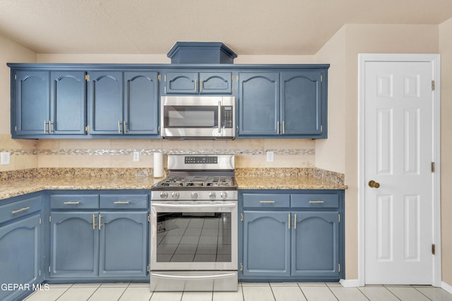 6800 Canyon Run Dr, El Paso, TX 79912 - kitchen featuring appliances with stainless steel finishes, blue cabinetry, tasteful backsplash, and light tile patterned floors