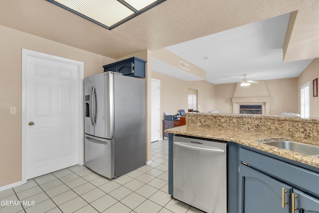 6800 Canyon Run Dr, El Paso, TX 79912 - kitchen featuring stainless steel appliances, blue cabinetry, a ceiling fan, open floor plan, and light tile patterned floors
