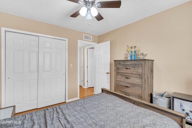 6800 Canyon Run Dr, El Paso, TX 79912 - bedroom with wood finished floors, ceiling fan, a closet, and a textured ceiling