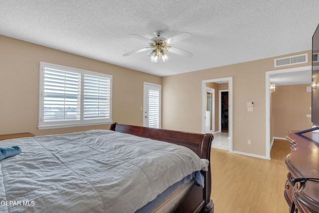 6800 Canyon Run Dr, El Paso, TX 79912 - bedroom with light wood-style flooring, a textured ceiling, a ceiling fan, and baseboards