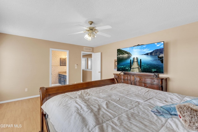6800 Canyon Run Dr, El Paso, TX 79912 - bedroom with wood finished floors, baseboards, ceiling fan, ensuite bathroom, and a textured ceiling