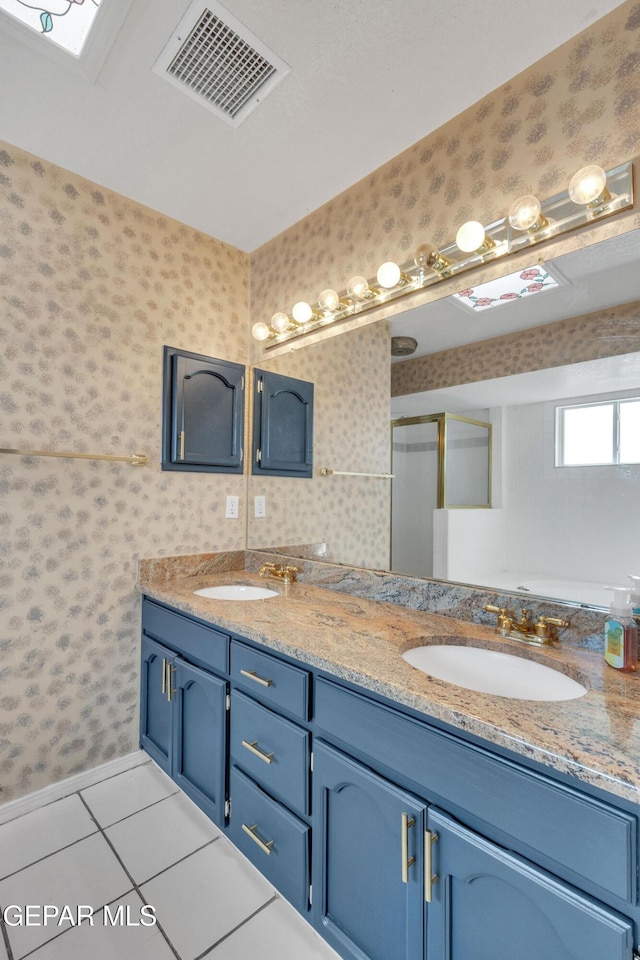 6800 Canyon Run Dr, El Paso, TX 79912 - full bathroom with wallpapered walls, double vanity, tile patterned flooring, baseboards, and a shower with shower door