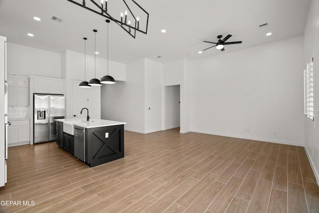 13376 Coldham St, El Paso, TX 79928 - kitchen with stainless steel appliances, a sink, open floor plan, light countertops, and dark cabinets