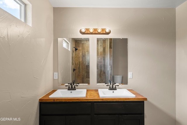 628 Milo Dr, El Paso, TX 79927 - full bathroom with double vanity, tiled shower, and toilet