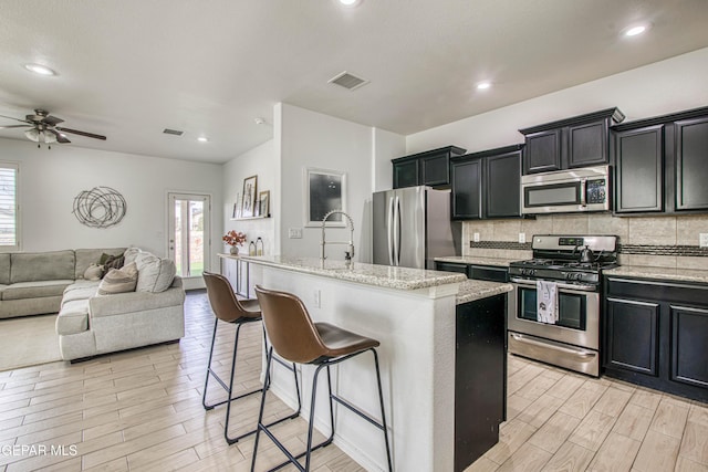 7517 Red Cedar Dr, El Paso, TX 79911 - kitchen featuring appliances with stainless steel finishes, open floor plan, healthy amount of natural light, light wood-style flooring, and recessed lighting