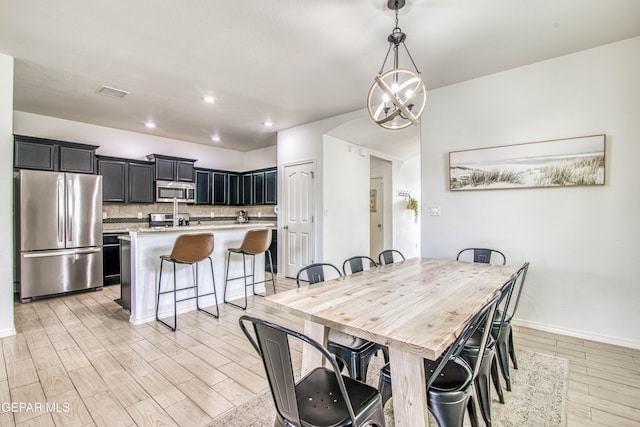 7517 Red Cedar Dr, El Paso, TX 79911 - dining area with light wood finished floors, baseboards, recessed lighting, and a chandelier