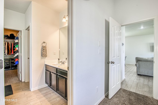 7517 Red Cedar Dr, El Paso, TX 79911 - bathroom featuring vanity, wood finished floors, baseboards, and a walk in closet