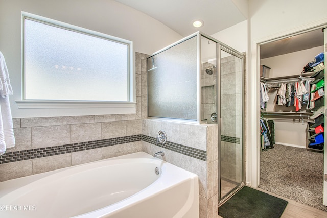 7517 Red Cedar Dr, El Paso, TX 79911 - bathroom featuring a bath, a stall shower, a spacious closet, and wood finished floors
