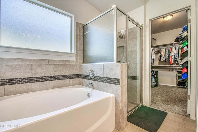 7517 Red Cedar Dr, El Paso, TX 79911 - bathroom featuring a bath, a shower stall, a walk in closet, and wood finished floors
