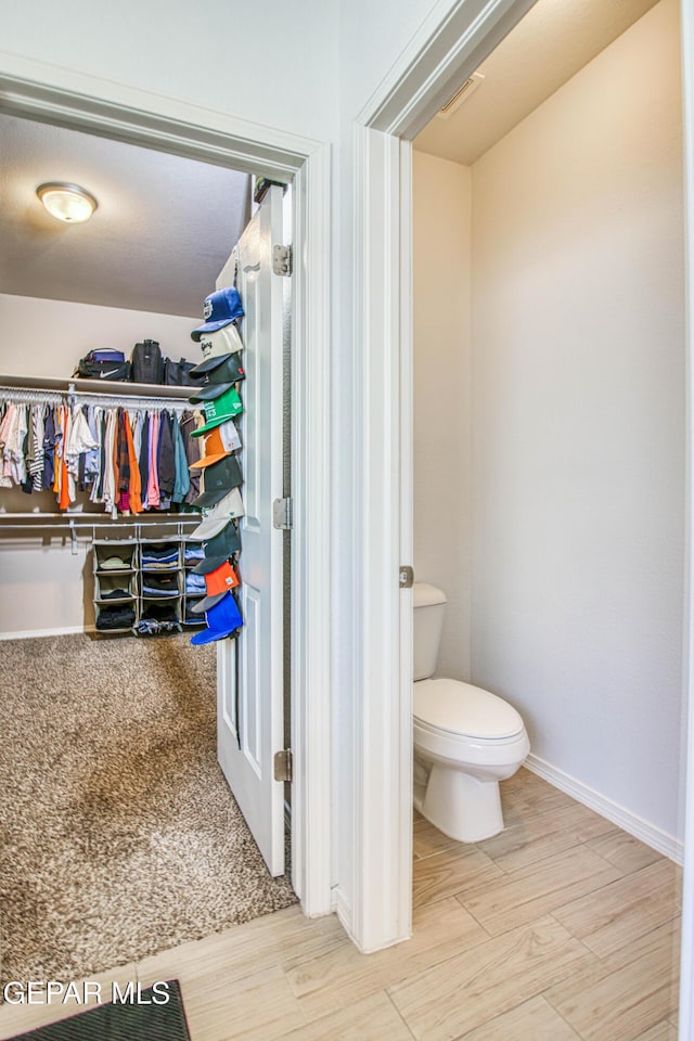 7517 Red Cedar Dr, El Paso, TX 79911 - bathroom featuring toilet, a walk in closet, and baseboards