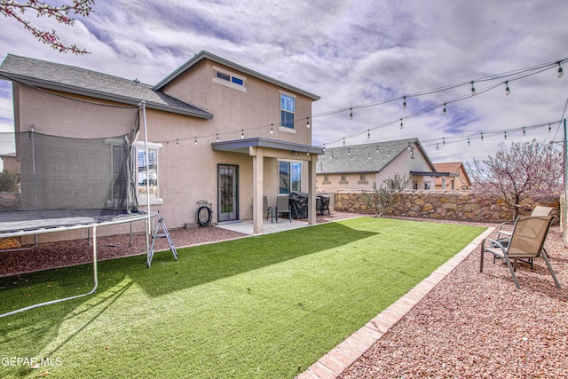7517 Red Cedar Dr, El Paso, TX 79911 - back of house with a trampoline, a patio area, and stucco siding