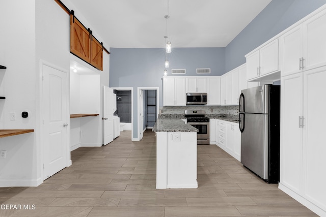 3899 Vanderveer Dr Unit A B C, El Paso, TX 79938 - kitchen featuring appliances with stainless steel finishes, tasteful backsplash, dark stone countertops, white cabinets, and light wood-type flooring