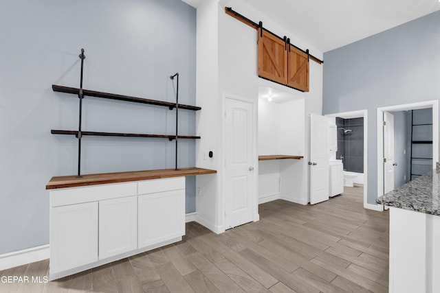3899 Vanderveer Dr Unit A B C, El Paso, TX 79938 - kitchen featuring a barn door, light wood-type flooring, baseboards, and a desk