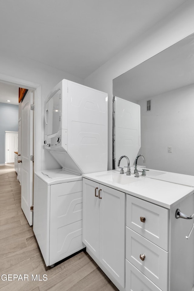 3899 Vanderveer Dr Unit A B C, El Paso, TX 79938 - laundry area with stacked washing machine and dryer, a sink, and light wood-style flooring