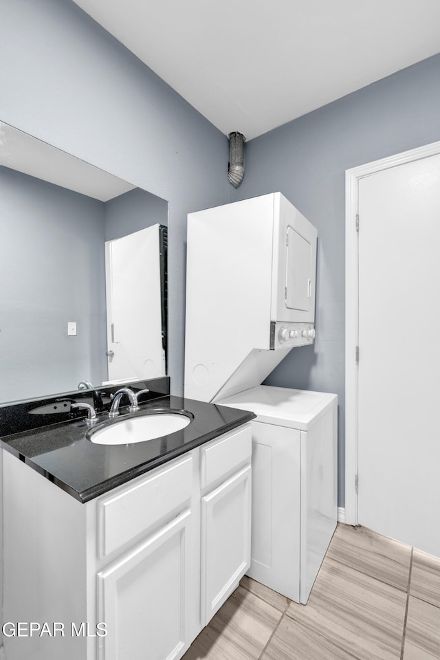 3899 Vanderveer Dr Unit A B C, El Paso, TX 79938 - washroom with stacked washing machine and dryer, a sink, and light wood-style flooring