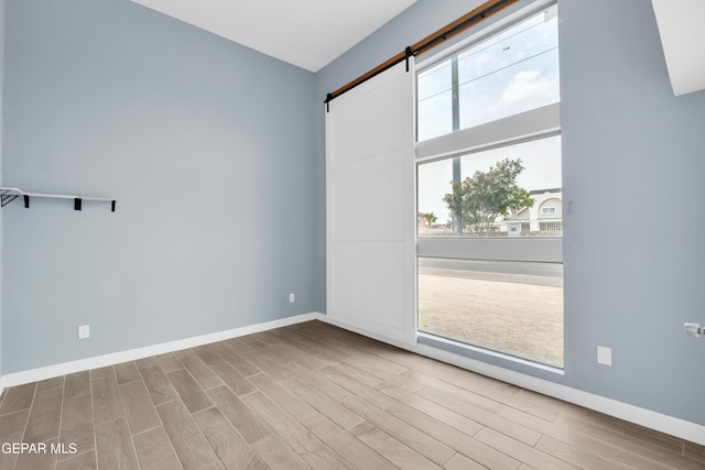 3899 Vanderveer Dr Unit A B C, El Paso, TX 79938 - spare room with a barn door, wood finished floors, and baseboards