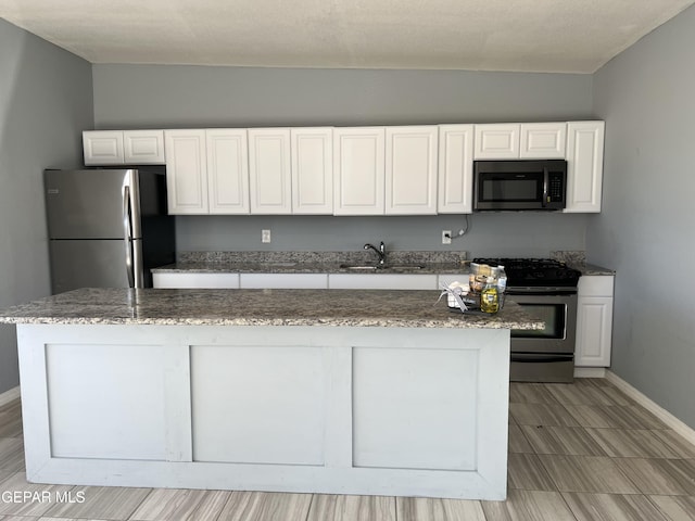 3899 Vanderveer Dr Unit A B C, El Paso, TX 79938 - kitchen with stainless steel appliances, a sink, white cabinetry, baseboards, and stone countertops