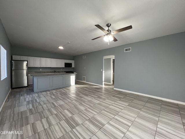 3899 Vanderveer Dr Unit A B C, El Paso, TX 79938 - kitchen featuring freestanding refrigerator, open floor plan, baseboards, black microwave, and lofted ceiling