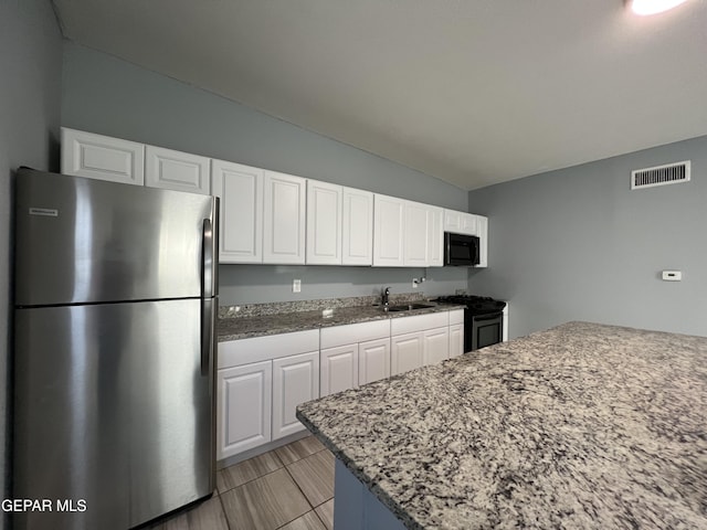 3899 Vanderveer Dr Unit A B C, El Paso, TX 79938 - kitchen featuring stainless steel appliances, a sink, vaulted ceiling, white cabinets, and light stone countertops