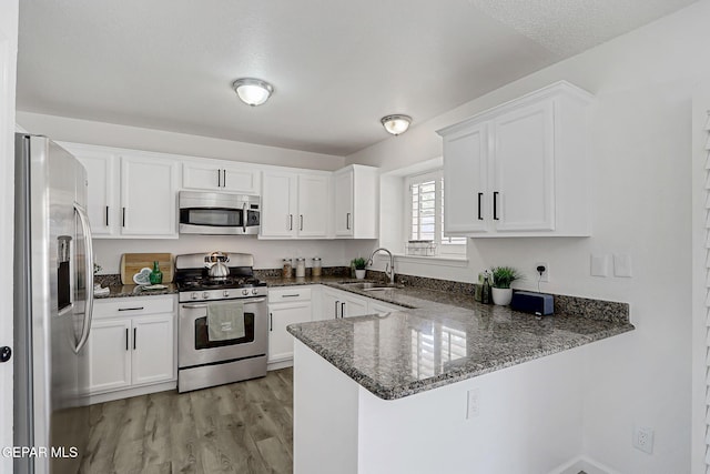 6929 Canyon View Ln, El Paso, TX 79912 - kitchen featuring stainless steel appliances, a peninsula, a sink, and white cabinetry