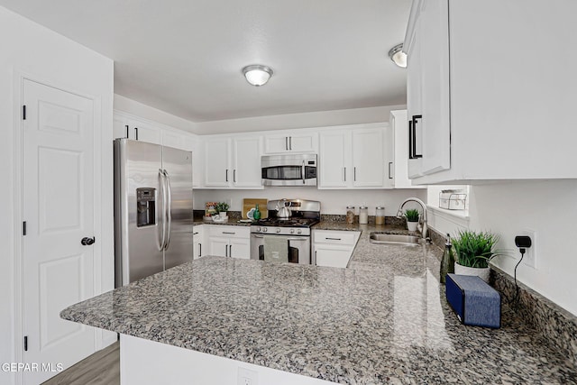 6929 Canyon View Ln, El Paso, TX 79912 - kitchen featuring stainless steel appliances, a sink, a peninsula, white cabinets, and dark stone counters