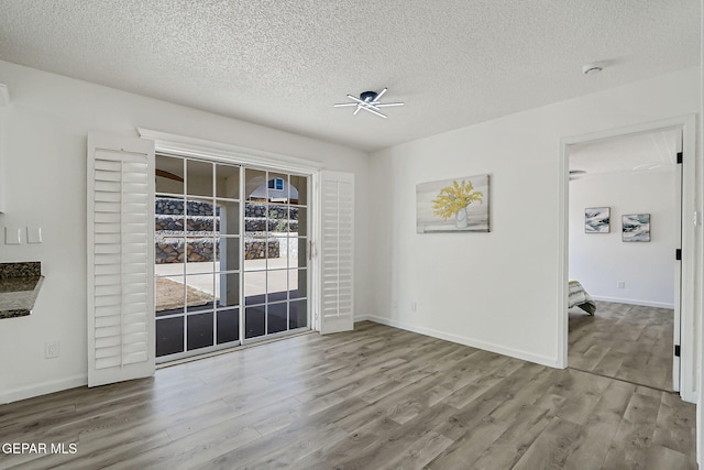 6929 Canyon View Ln, El Paso, TX 79912 - unfurnished dining area with wood finished floors, a textured ceiling, ceiling fan, and baseboards