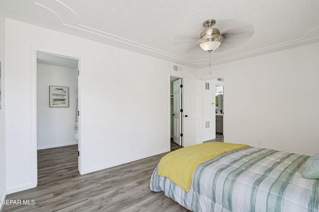 6929 Canyon View Ln, El Paso, TX 79912 - bedroom with a textured ceiling, wood finished floors, and baseboards