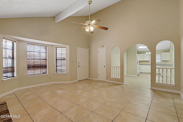 12013 Meadow Gate Dr, El Paso, TX 79936 - empty room featuring light tile patterned flooring, a ceiling fan, beam ceiling, arched walkways, and baseboards
