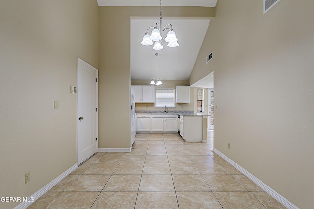 12013 Meadow Gate Dr, El Paso, TX 79936 - kitchen with high vaulted ceiling, a chandelier, white cabinetry, white fridge with ice dispenser, and decorative light fixtures