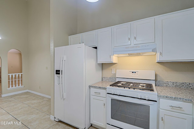 12013 Meadow Gate Dr, El Paso, TX 79936 - kitchen featuring under cabinet range hood, white appliances, white cabinetry, arched walkways, and a towering ceiling