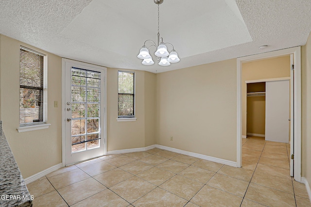 12013 Meadow Gate Dr, El Paso, TX 79936 - unfurnished dining area with light tile patterned floors, a chandelier, a textured ceiling, and baseboards