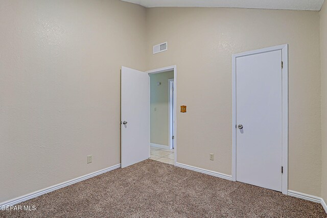12013 Meadow Gate Dr, El Paso, TX 79936 - unfurnished bedroom with light carpet, vaulted ceiling, and baseboards