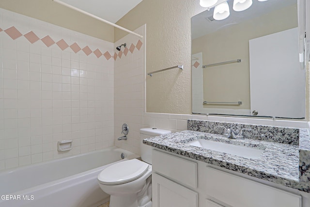 12013 Meadow Gate Dr, El Paso, TX 79936 - bathroom featuring a textured wall, vanity, toilet, shower / bathtub combination, and tile walls