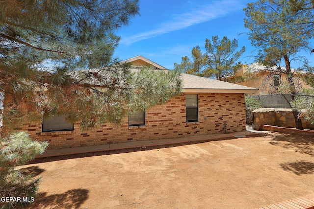 12013 Meadow Gate Dr, El Paso, TX 79936 - view of side of home with brick siding and roof with shingles